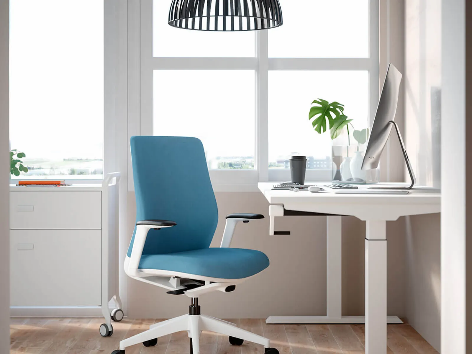 Silla A+S Work azul frente a una mesa elevable en un despacho montado en casa
