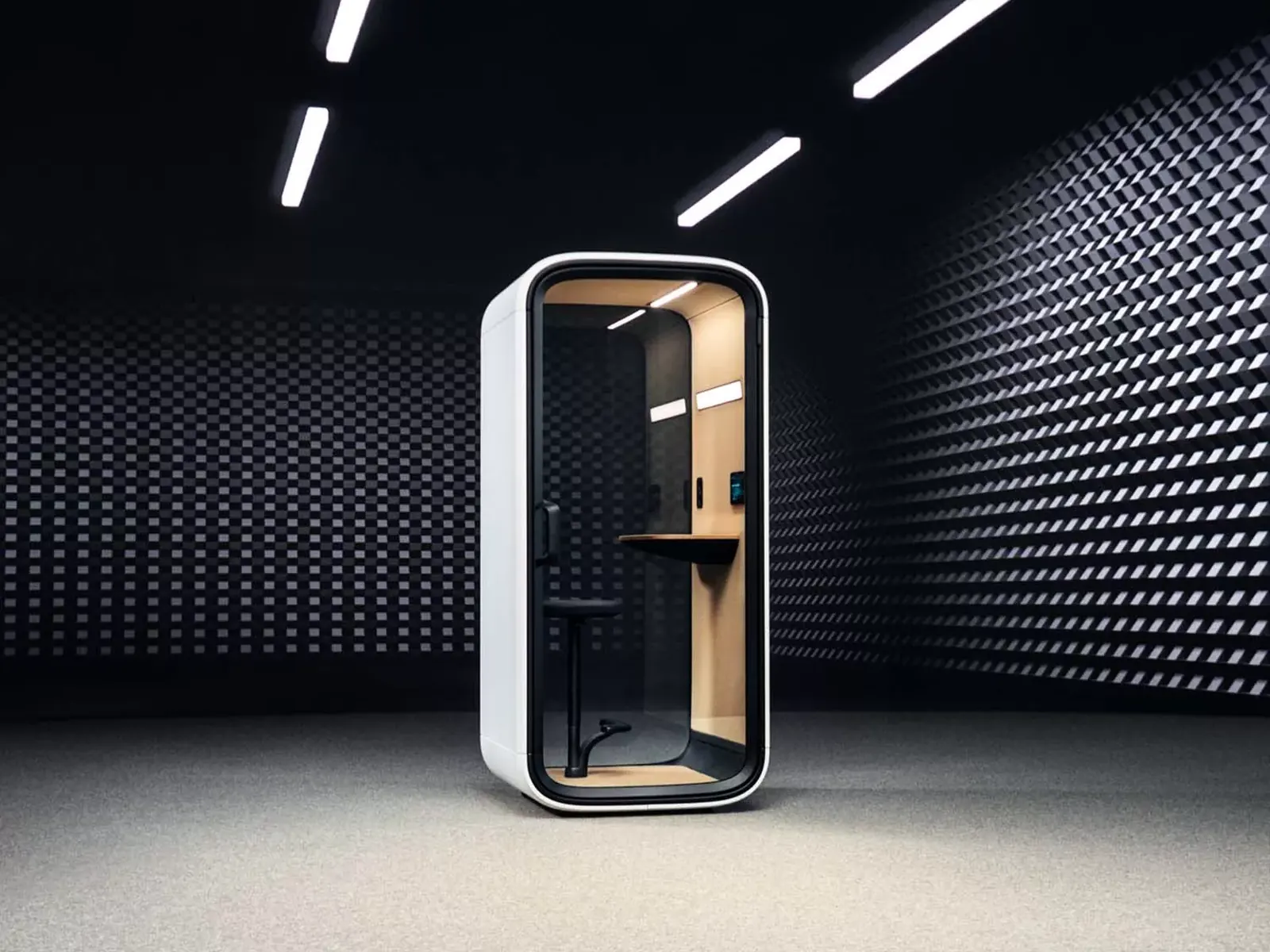 Framery One Compact en un espacio oscuro con iluminación de acento