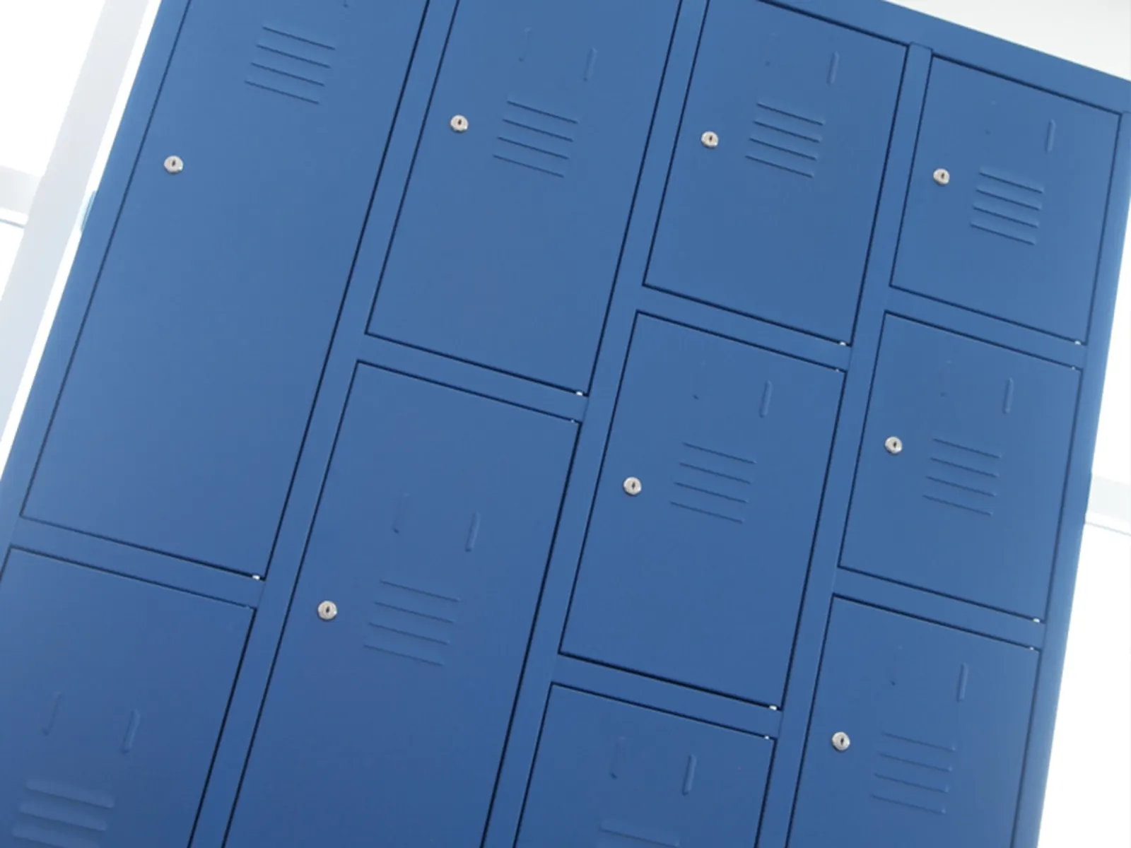 Detalle de las cerraduras de cilindro de una batería de taquillas metálicas Gapsa en azul