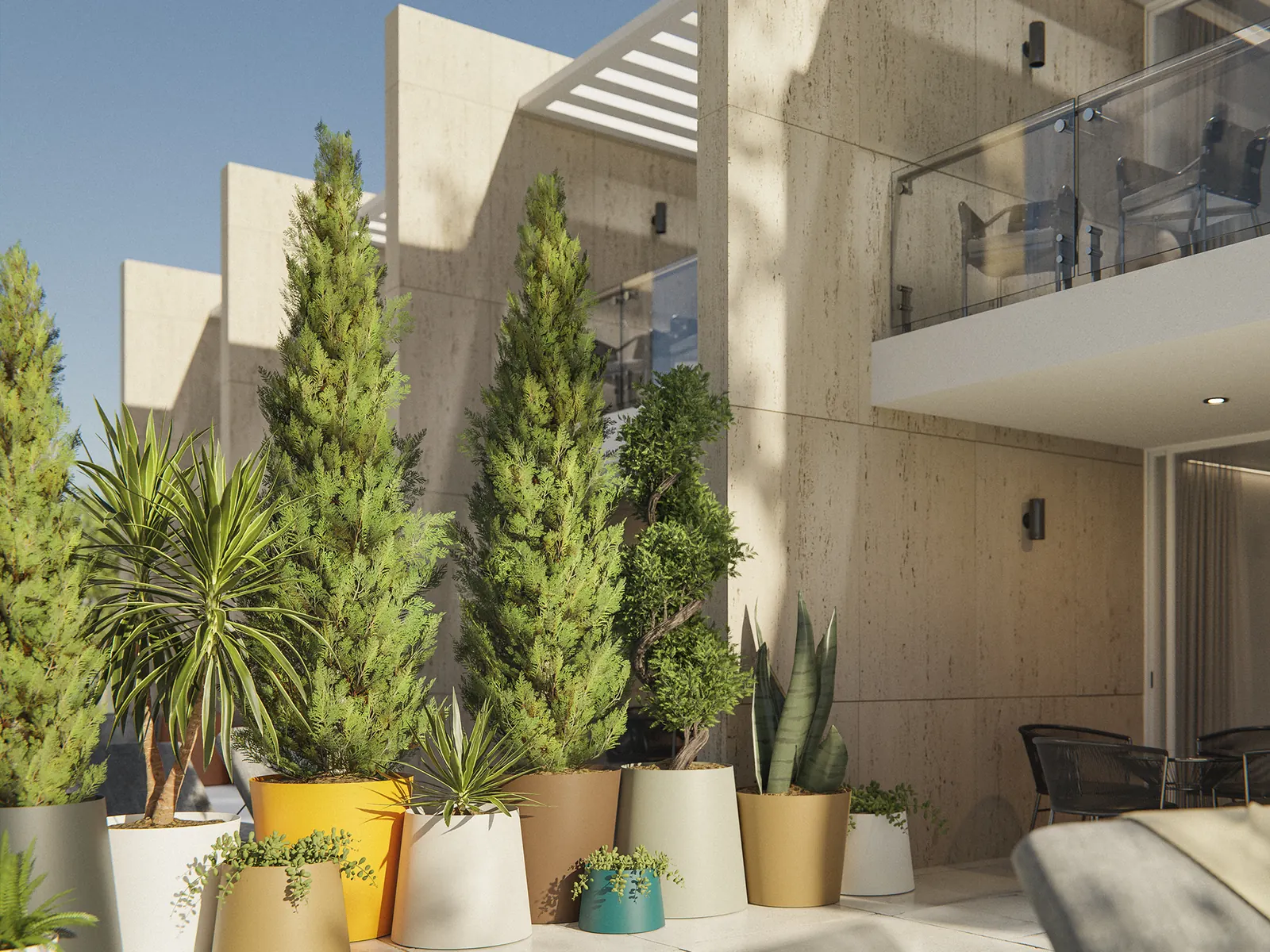 Jardineras Made Design Nipori de distintos colores junto a plantas, en una terraza